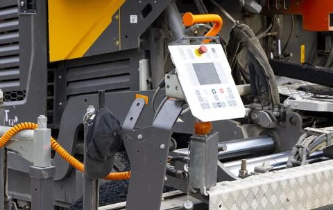 Worker operating asphalt paver machine during road construction and repairing Stock Photos