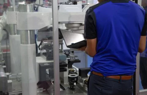 Worker operating assembly robot Stock Photos