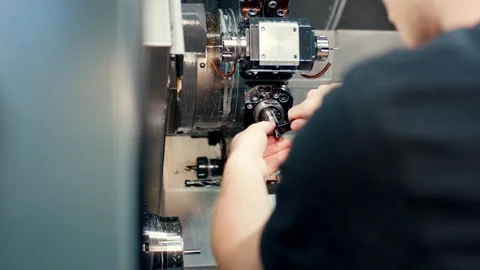 Worker operating a CNC turning machine in a metal workshop, Over the Shoulder Vídeo Stock 342290579