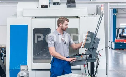 Worker operating computer-controlled machine tool Fotos de archivo