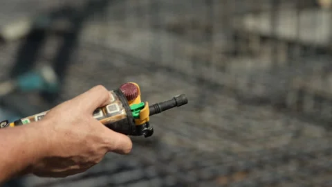 Worker operating concrete pump with handheld remote control Stockbeeldmateriaal 344606239