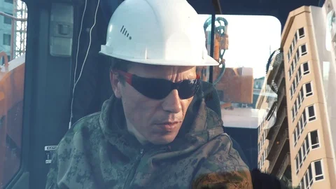 Worker operating a crane at a construction site Stock Footage 89872934