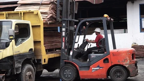 Worker operating forklift beside yellow truck Vídeos de archivo 104949406