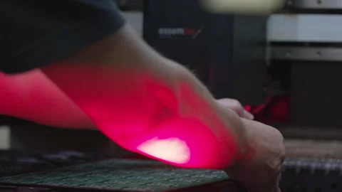 Worker operating machine to build electronics circuit boards Stock Footage 252757716