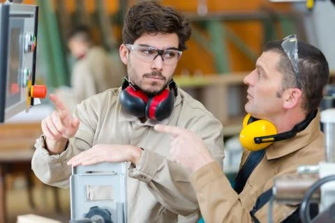 Worker operating a machine in a factory Stock Photos