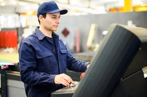 Worker operating a machine in a factory Fotos de archivo
