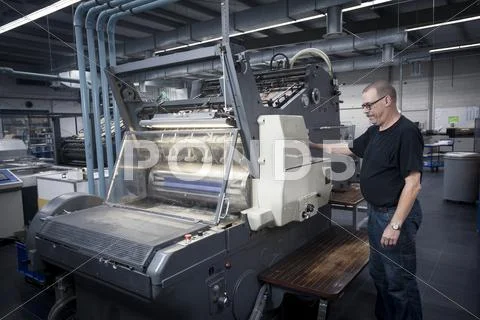 Worker Operating Print Machine In Printing Workshop