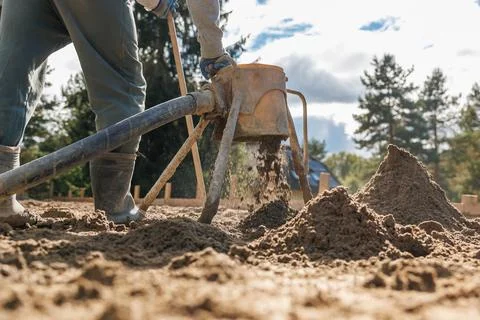 Worker Operating Sandblasting Machine on Sandy Surface with Trees Stock-Fotos