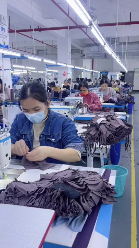 Worker Operating Sewing Machine in a Chinese Garment Factory Video stock 328447714
