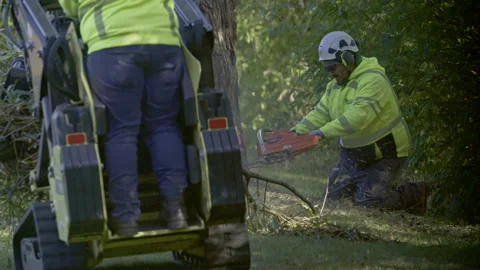 Worker operating a small tracked loader, mini skid steer equipped with clamp or Stock Footage 321040203