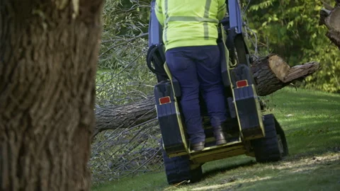 Worker operating a small tracked loader , mini skid steer equipped with a clamp Stock Footage 321043400