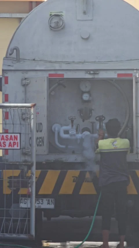 Worker Operating Valves On A Liquid Oxygen Delivery Truck Behind A Safety Stock Footage 340002316