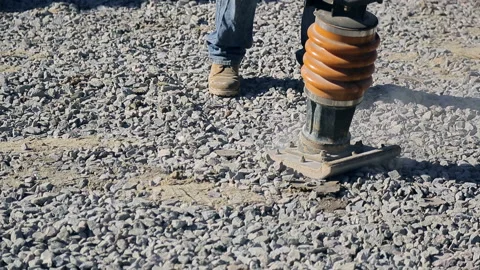 Worker operating a Vibratory Rammer Compactor.Vibratory rammer in action on a Stock Footage 102381566