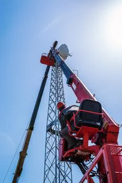Worker operator of the aerial platform at the workplace Stock Photos