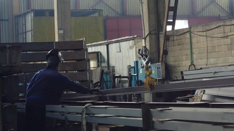 Worker or employee or mechanical technician with a crane lifts a stack of new lo Video stock 121190112