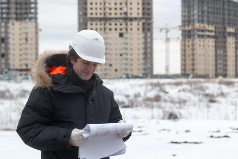 Worker or engineer holding drawing in hands and reading it on background of new Stock Photos