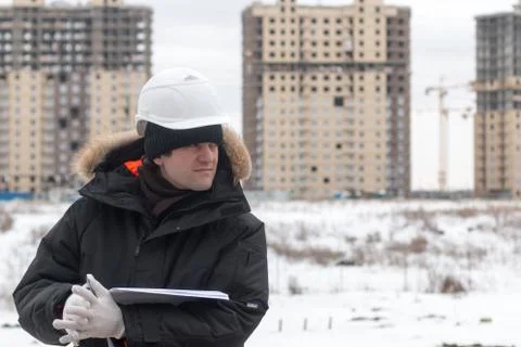 Worker or engineer holding drawing in hands and reading it on background of new Stock Photos