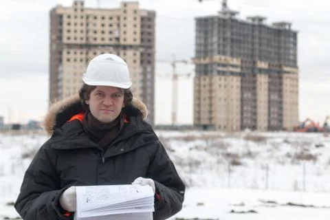 Worker or engineer holding drawing in hands and reading it on background of new Stock Photos