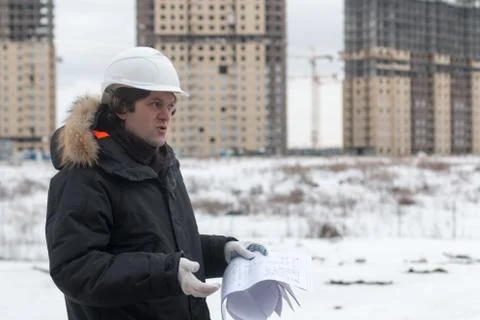 Worker or engineer holding drawing in hands and reading it on background of new Stockfoto's