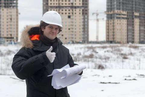 Worker or engineer holding drawing in hands and reading it on background of new Stock Photos