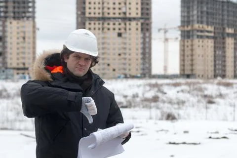 Worker or engineer holding drawing in hands and reading it on background of new Stock Photos