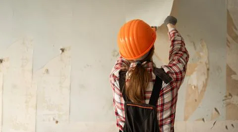 Worker or repairman removing old wallpaper from the wall. house renovation re Stock Photos