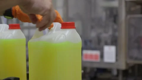 Worker in Orange Gloves Handling Yellow Chemical Canister in Factory Stock Footage 336612888
