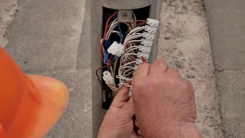 Worker in an orange hard hat of special company maintains electrical equipment Stock Footage 270519141