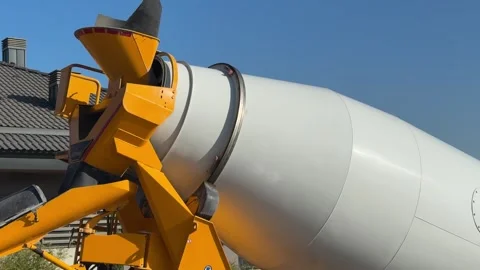 A worker in an orange shirt is sitting next to a large white and yellow 스톡 동영상 332618461