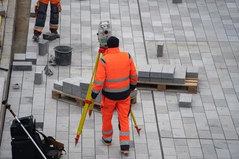 Worker in orange uniform doing construction measure. Concept of development Stock Photos