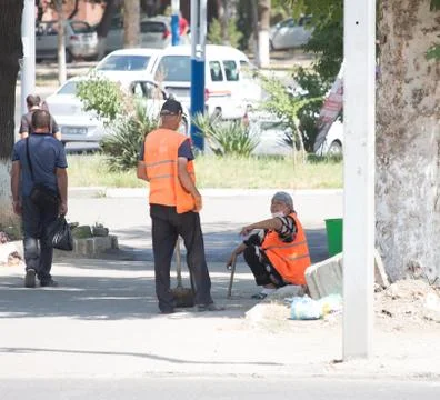 Worker in an orange vest does work on the street.24.06.2020 Tashkent,Uzbekistan Stock Photos