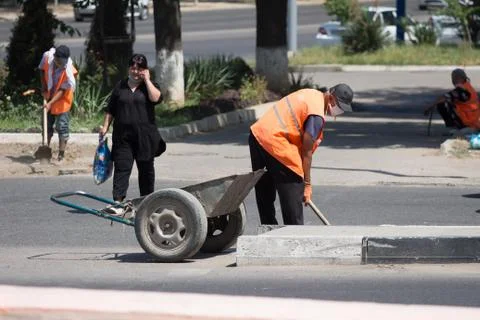 Worker in an orange vest does work on the street.24.06.2020 Tashkent,Uzbekistan Stock Photos