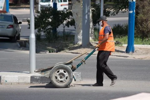 Worker in an orange vest does work on the street.24.06.2020 Tashkent,Uzbekistan Stock Photos