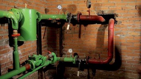A worker in overalls opens the water valve. The man includes heating in the 動画素材 76259353