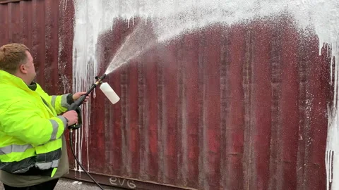 Worker in overalls washes a sea container. Stock Footage 306078948