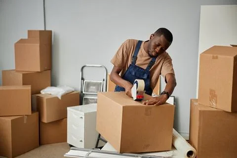 Worker packing boxes during relocation Stock Photos