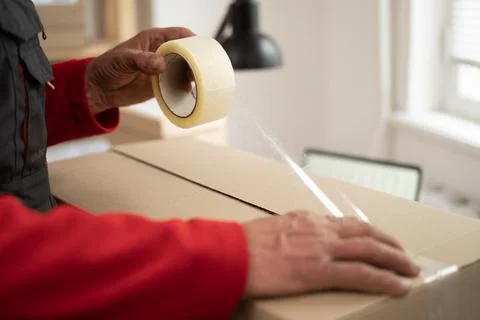 Worker packing boxes working in storage for startup or small business Stock Photos