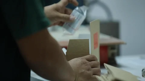 Worker packing manually Subway Tickets in a cardboard box in industrial factory. Stock Footage 110771717