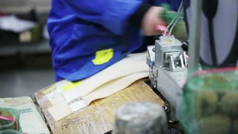 Worker packs containers with kiwi in mesh bags. Grocery suppliers and retailers Video stock 199486931