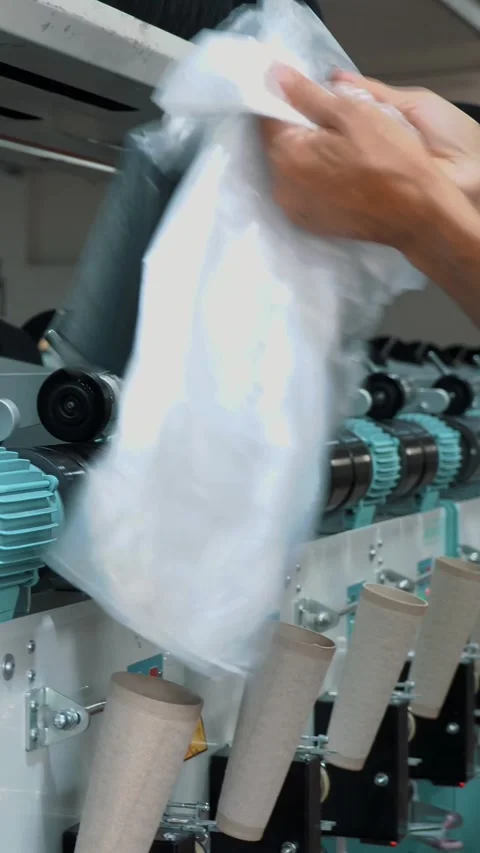 A worker packs spools of yarn. Textile factory equipment. Textile factory. Stock Footage 316134489