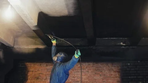Worker painting the ceiling by airless spray gun with black color. Airless Spray Stock Footage 108757780