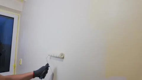 Worker painting interior wall with roller in residential room Stock Footage 335315175