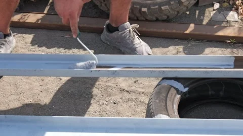 Worker painting metal structure with a roller 库存影片 347169072