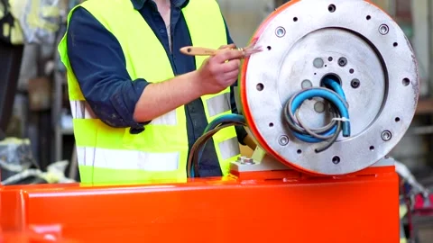 A worker painting a part of a robotic arm Stock Footage 255732356