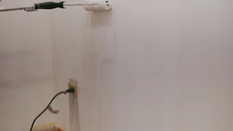 Worker painting wall with brush roller from the floor to the ceiling. Interior Stock Footage 334062778