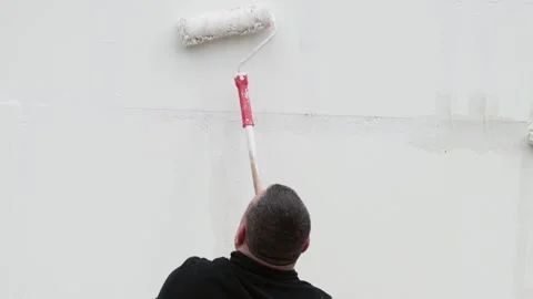 Worker painting white wall with long handle paint roller during home renova.. Vidéo 336307349