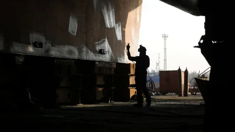 Worker paints  the bottom  of  the  ship in a dry dock. Stock-Footage 87085686