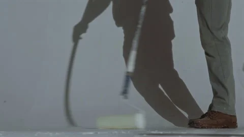 A worker paints the floor of a cyclorama in the room of a photo studio with 库存影片 338290652