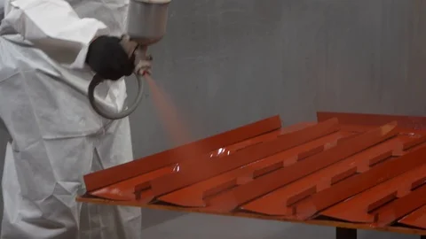 Worker paints metal in workshop, protecting parts, close-up, protective suit Stock Footage 120064409