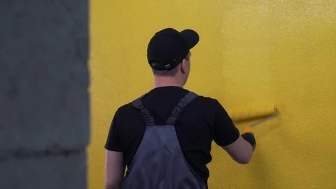 Worker paints a wall in bright colour Stock Footage 121189186